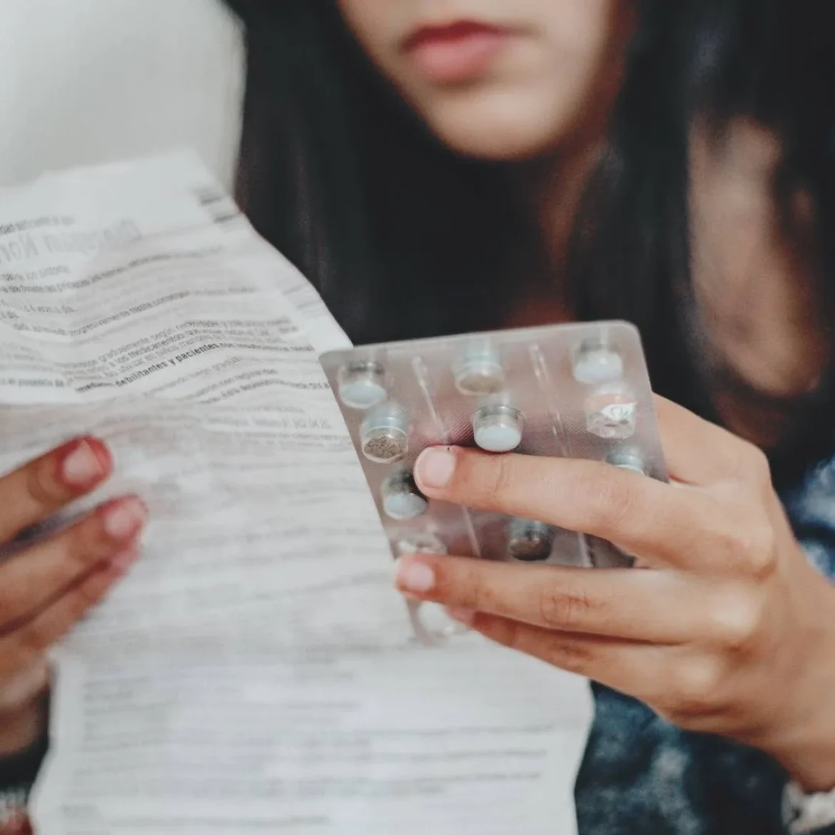 Vrouw leest bijsluiter van pil | Hormonen