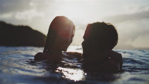 man en vrouw kijken elkaar aan in de zee