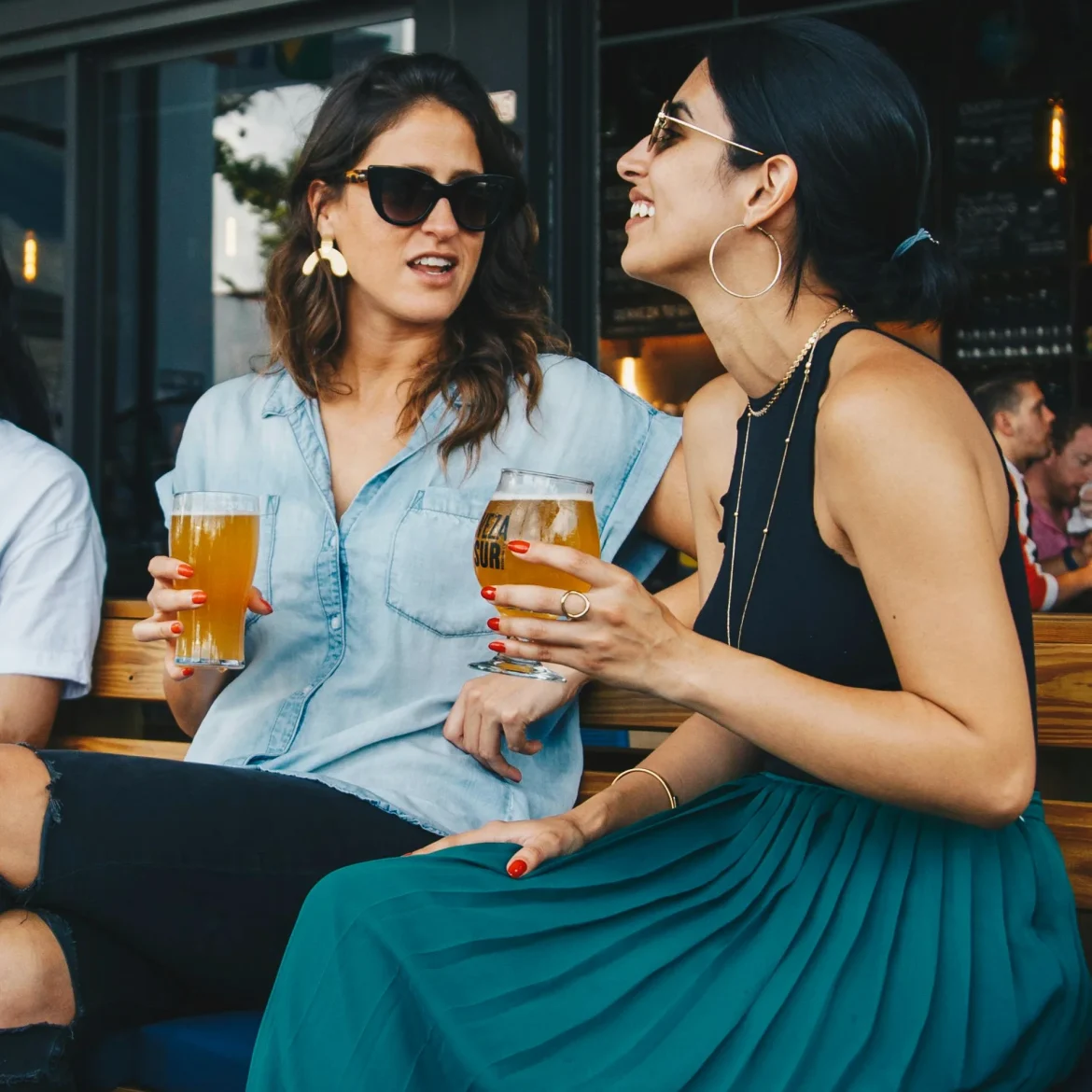 Drie vrouwen op een bankje bij café Besties